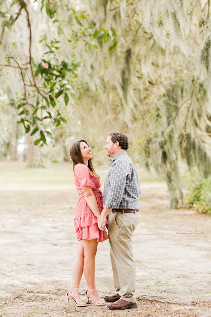 couple standing under trees covered with spanish moss